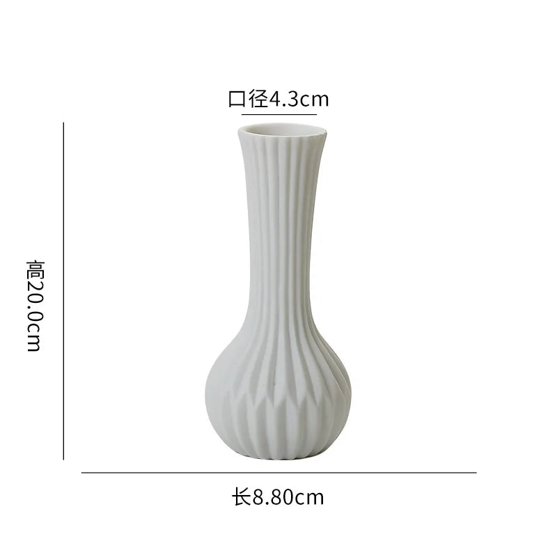 Vase blanc élégant et moderne avec des lignes verticales sculptées, mesurant 8,80 cm de hauteur et 4,3 cm de diamètre.