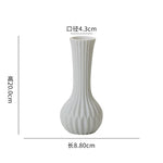 Vase blanc élégant et moderne avec des lignes verticales sculptées, mesurant 8,80 cm de hauteur et 4,3 cm de diamètre.