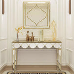 Un meuble console élégant en métal doré avec un miroir décoratif assorti, orné de figurines et d'accessoires dans un style contemporain raffiné.