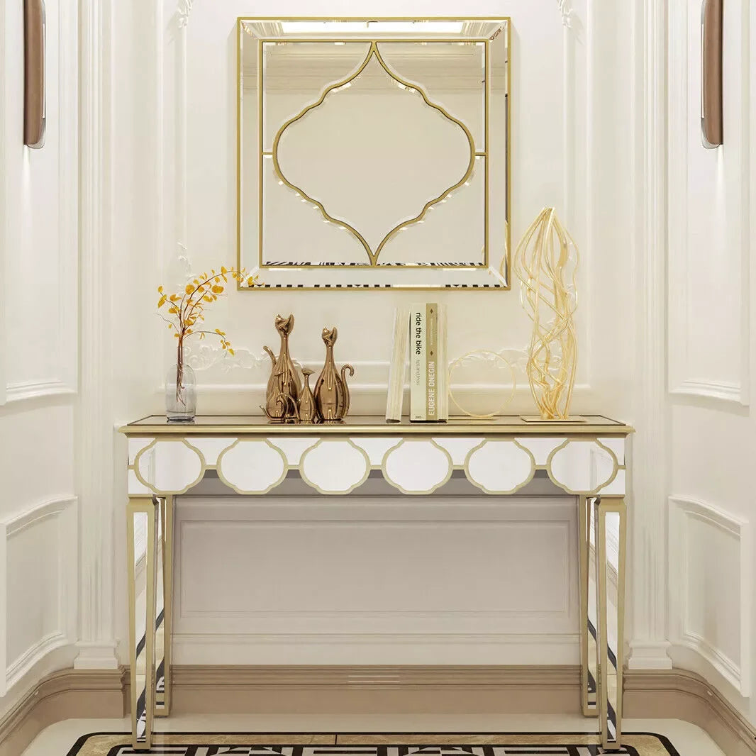 Un meuble console élégant en métal doré avec un miroir décoratif assorti, orné de figurines et d'accessoires dans un style contemporain raffiné.