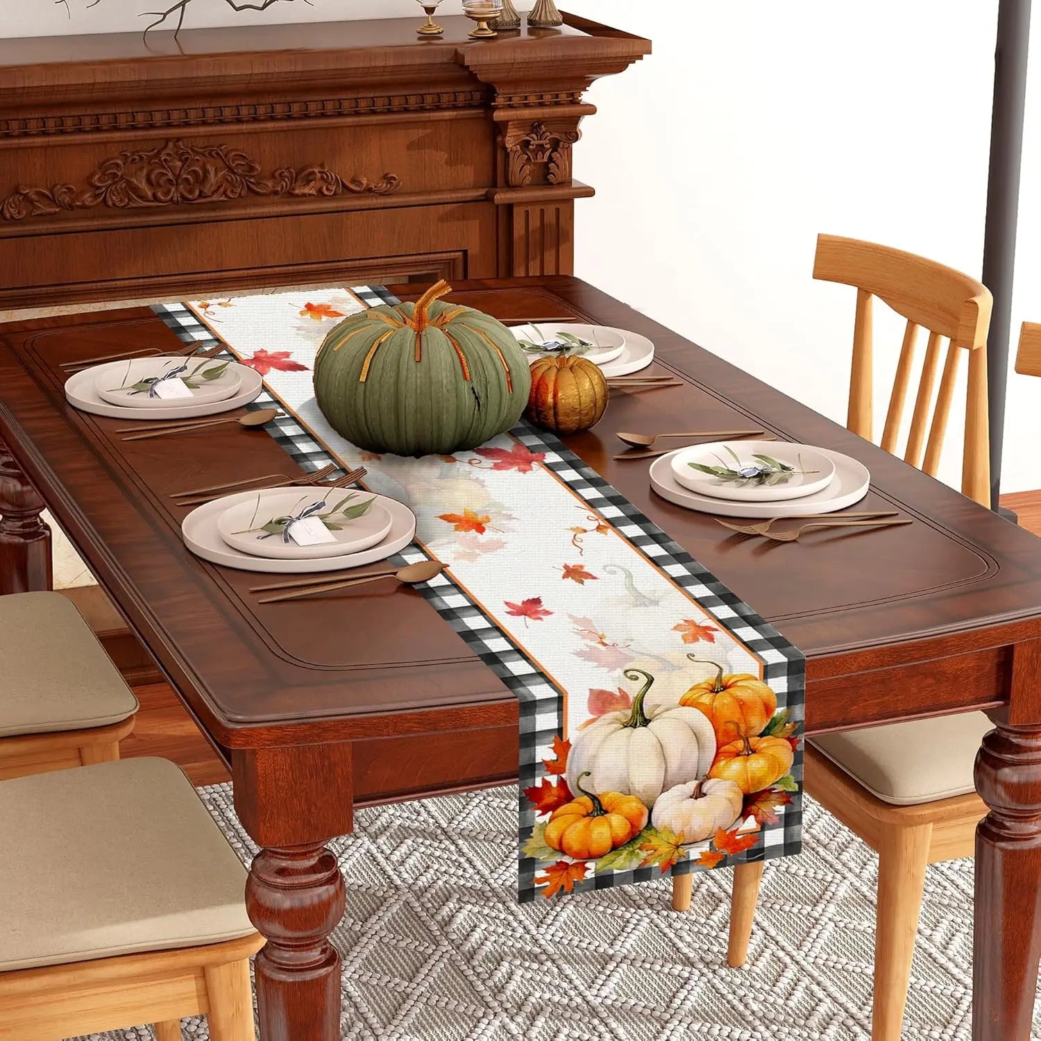 Une table de salle à manger en bois richement ornée avec des décorations d'automne, comprenant des citrouilles, des feuilles et une nappe à motifs.