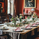 Une table de banquet richement décorée avec des fleurs, des fruits et une belle toile dans un intérieur élégant.
