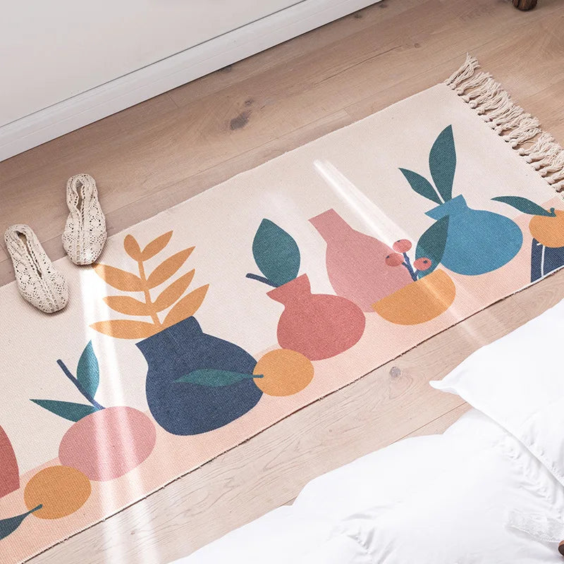 Motif abstrait coloré avec formes géométriques et feuilles stylisées sur un tapis posé sur un sol en bois.