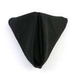 Gros plan sur un vêtement noir plié délicatement sur un fond blanc, offrant un contraste saisissant et mettant en valeur la texture et le design de ce vêtement.