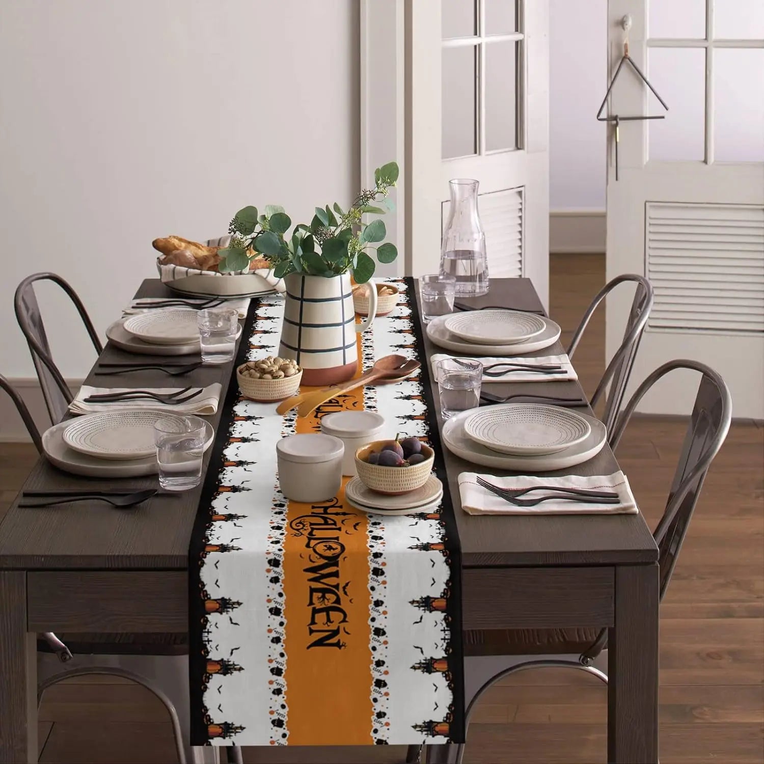 Une table de salle à manger élégante décorée avec de beaux plats, verres et accessoires de cuisine dans un style moderne.