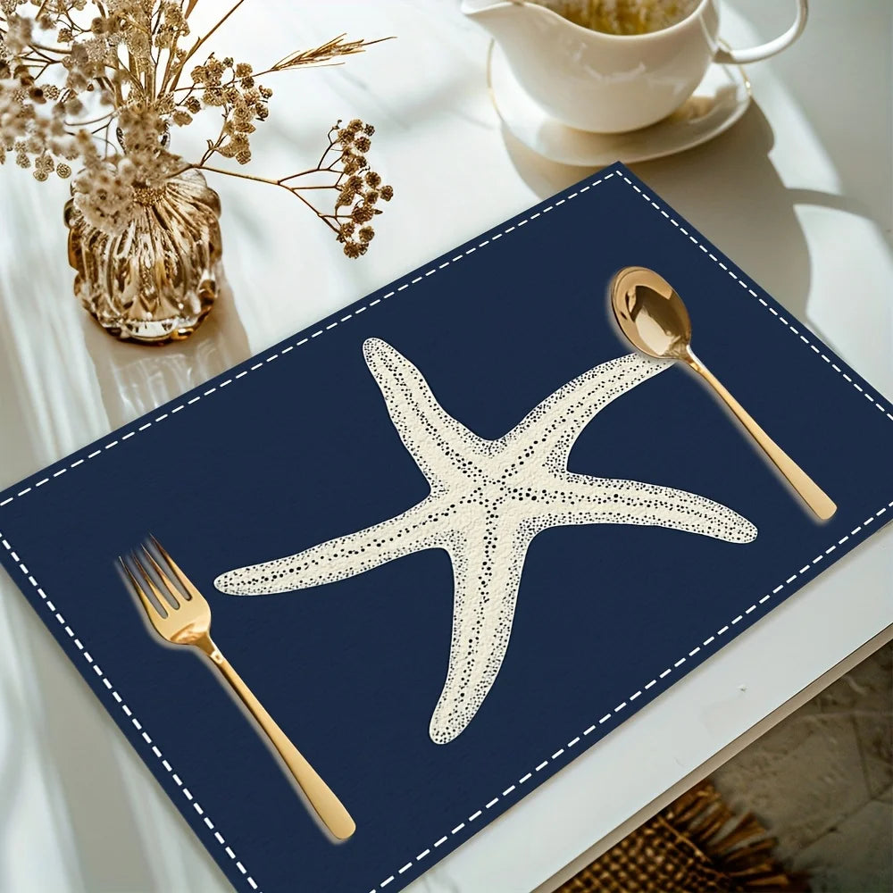 serviettes table bleu marine étoiles mer moderne fourchettes cuillers tasses soucoupes vase fleurs assiettesscrição