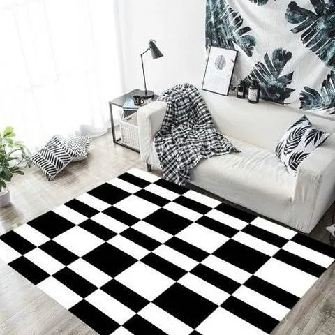 Le salon moderne montre un canapé blanc et un tapis noir et blanc à motif damier, créant une ambiance élégante et épurée.