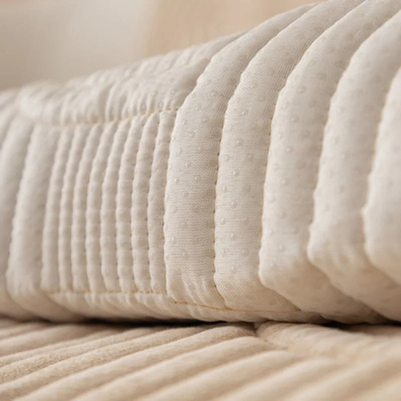 Un gros plan sur un tas de draps blancs moelleux et plissés, offrant une texture douce et accueillante pour un confort optimal.