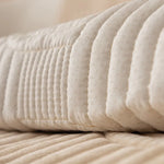 Un gros plan sur un tas de draps blancs moelleux et plissés, offrant une texture douce et accueillante pour un confort optimal.