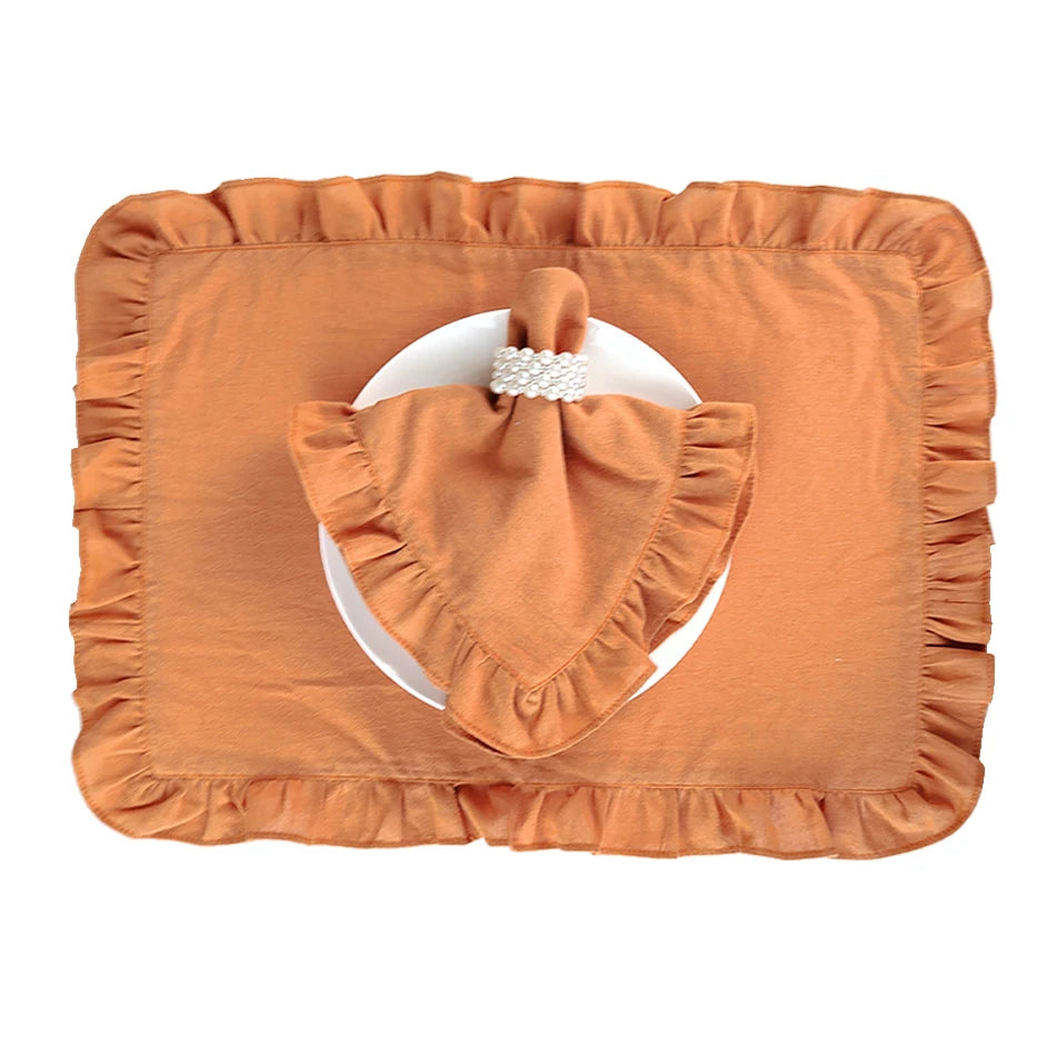 Un joli chemin de table de couleur orange avec des volants et un décor en forme de cœur au centre, décoré d'un élément en perles.