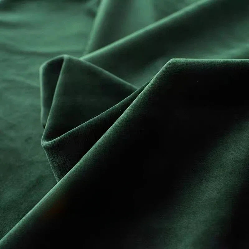 Tissu de velours vert forêt en gros plan, révélant une texture douce et luxueuse idéale pour une ambiance cocooning.