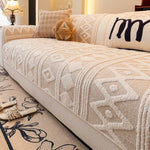 Le motif géométrique neutre et délicat sur le couvre-lit crée une ambiance confortable et accueillante dans la chambre.