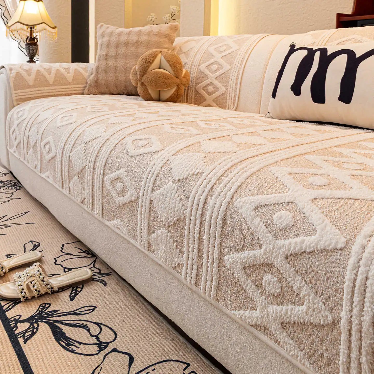 Le motif géométrique neutre et délicat sur le couvre-lit crée une ambiance confortable et accueillante dans la chambre.