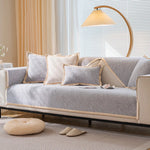 Un canapé confortable avec des oreillers décoratifs, éclairé par une lampe de sol, créant une atmosphère chaleureuse et accueillante dans cette pièce.