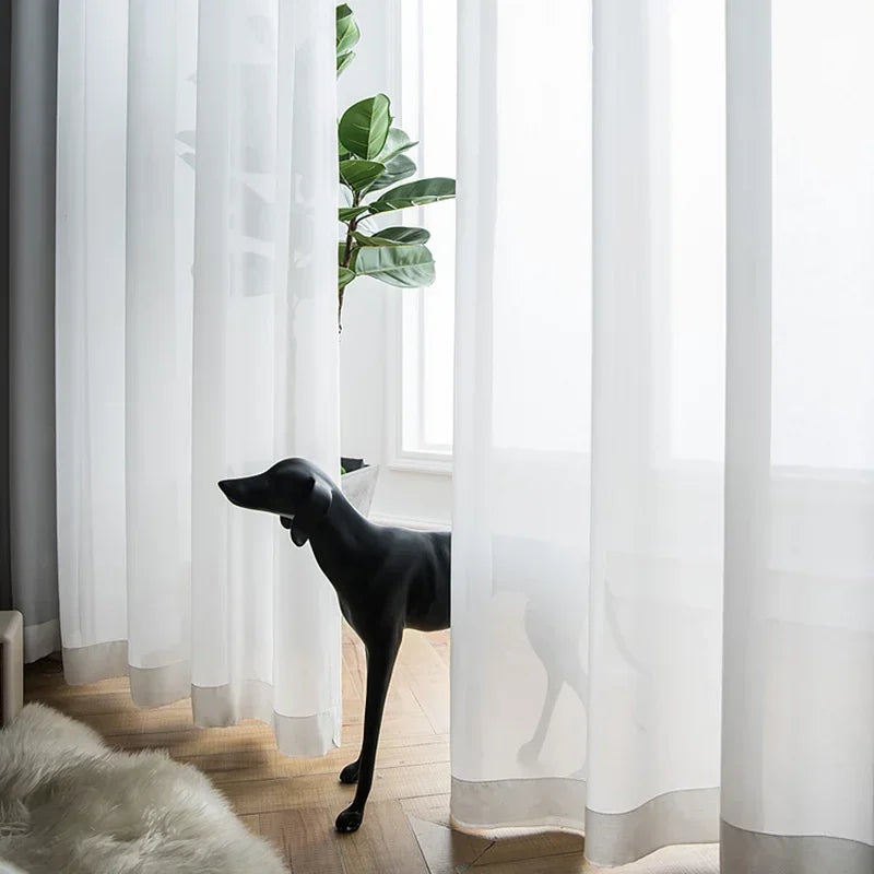 Rideaux translucides blancs élégants pour salon, offrant une ambiance lumineuse et moderne. Idéals pour filtrer la lumière tout en préservant l'intimité. Accessoire parfait pour une décoration intérieure raffinée.