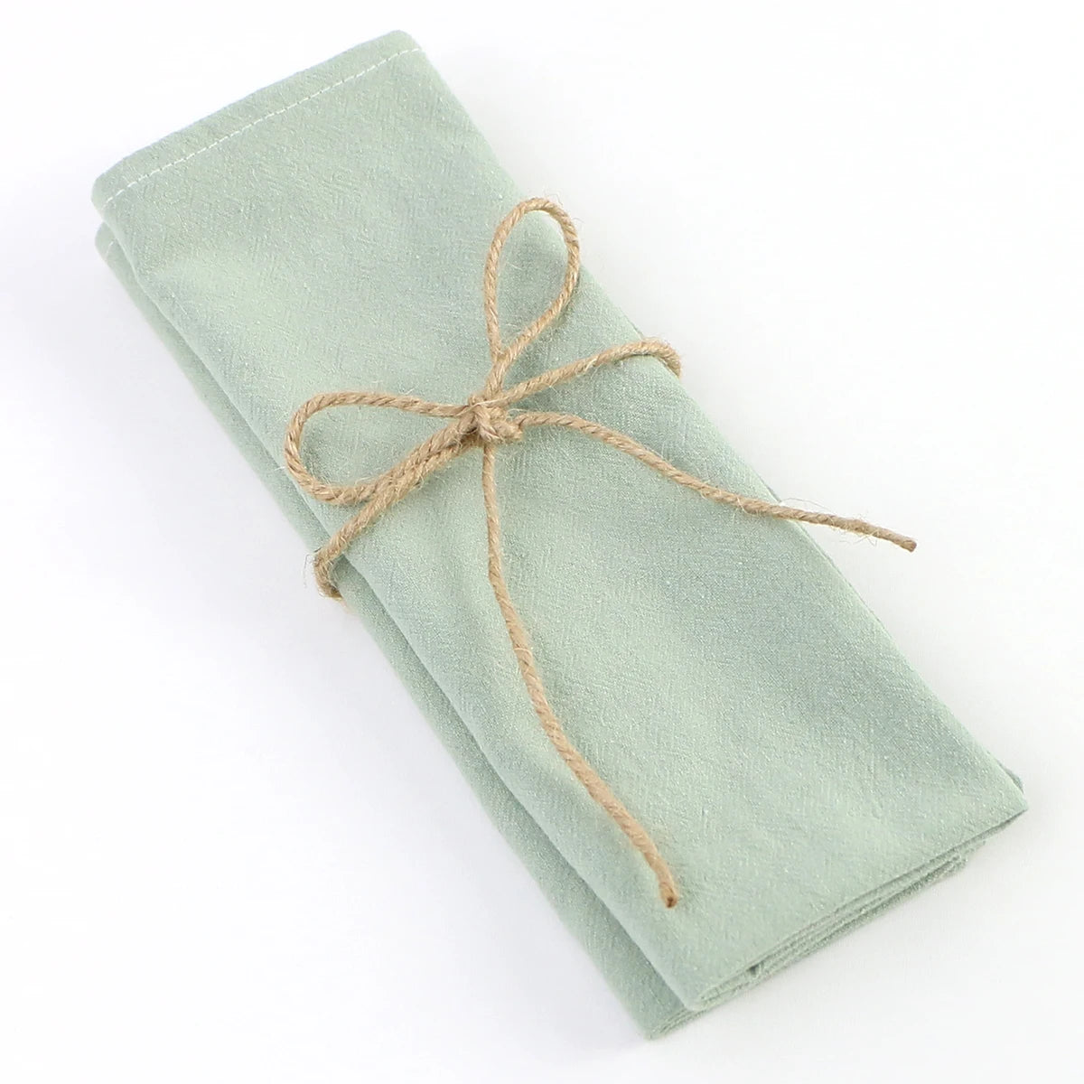 Élégante écharpe en tissu doux de couleur verte pâle, soigneusement enroulée et attachée par un joli lien de chanvre, créant une présentation raffinée et invitante.