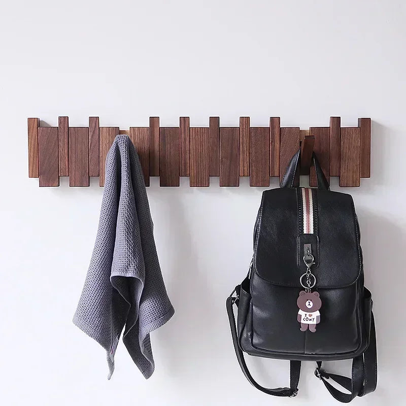 Porte-manteau mural en bois massif perforé noir accroché dans un salon contemporain