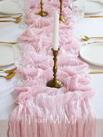 L'image montre une magnifique table de fête décorée de fleurs roses délicates et de bougies dorées, avec des couverts élégants disposés avec soin.