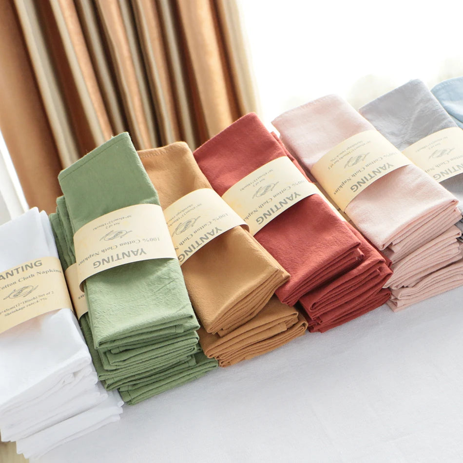 Une pile de serviettes de cuisine dans différentes couleurs vives, prêtes à être utilisées.