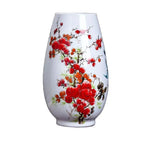 Un magnifique vase en verre blanc décoré de fleurs de cerisier rouges épanouies et de branches délicates.