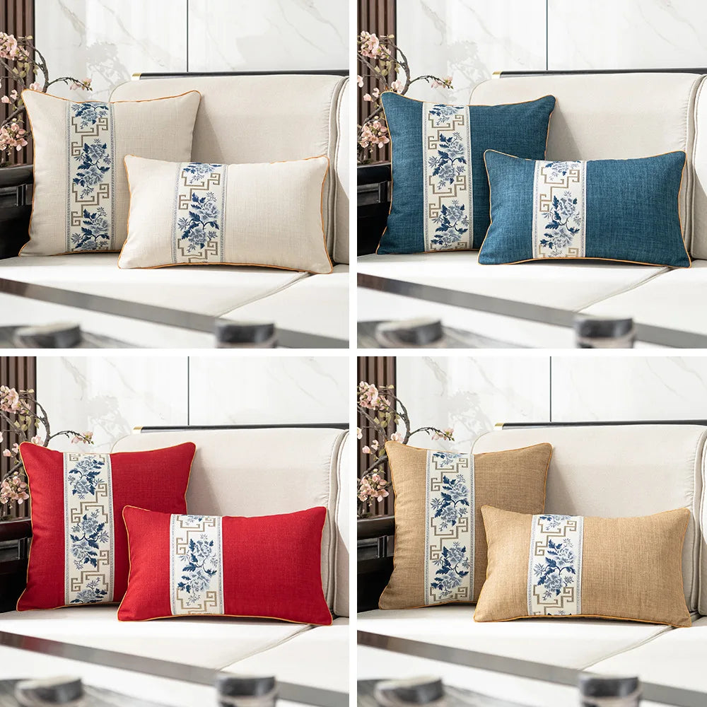 Élégants coussins décoratifs bleus, rouges et beiges ornés de motifs floraux traditionnels sur un canapé en tissu clair.
