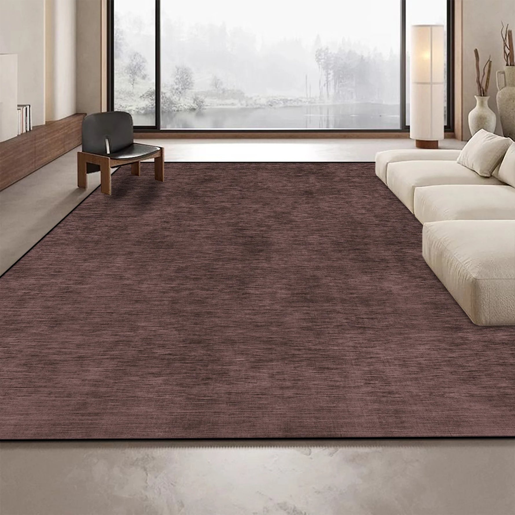 Un grand tapis en fibres textiles brunes couvre le sol d'un salon moderne avec de grandes fenêtres offrant une vue sur le paysage extérieur.