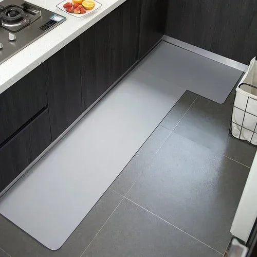 Cuisine moderne avec comptoir en acier inoxydable et carrelage gris, offrant un espace de travail pratique et un style épuré.