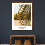 Une photo encadrée représentant une feuille de palmier dorée sur un fond sombre, avec l'indication "La Caravelle, Guadeloupe" en dessous.