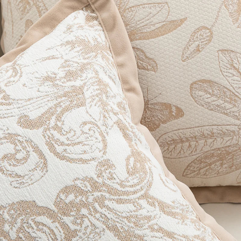 Cette image représente un gros plan d'un motif décoratif composé de fleurs et de feuilles sur un tissu beige aux tons neutres, créant une ambiance apaisante et élégante.