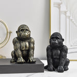Statue de gorille en résine gris clair sur étagère de salon