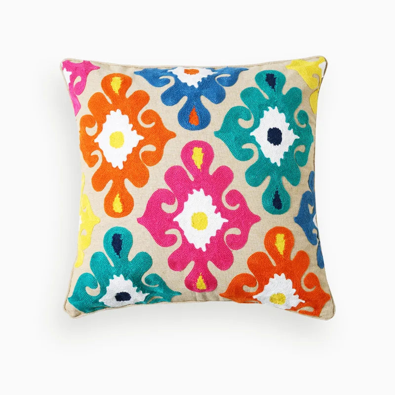 Coussin décoratif coloré avec un motif floral ethnique et vibrant.