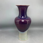 Vase en céramique de couleur violette avec des motifs décoratifs.