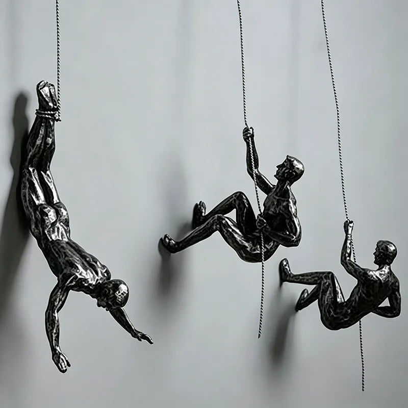 ornements statuettes grimpeurs noir sculptures détaillées art contemporain fixations chaînes socles décoration murale