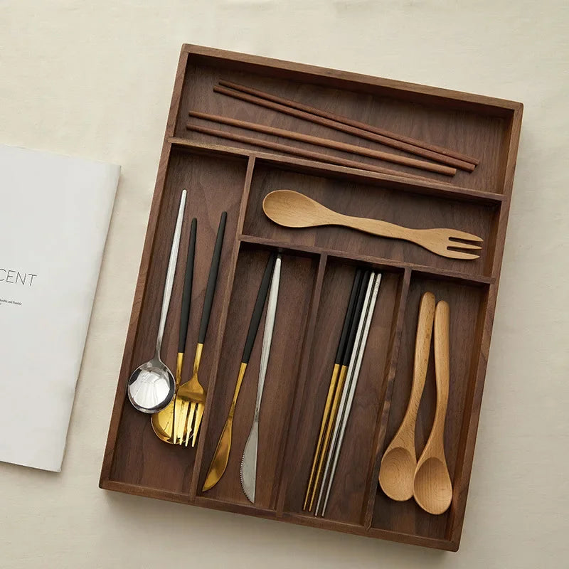 Boîte de rangement en bois noir dans un tiroir de cuisine organisé
