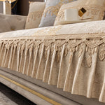 Détail d'un lit avec des coussins ornés de motifs et de franges ornementales, créant une ambiance luxueuse et élégante dans la chambre.