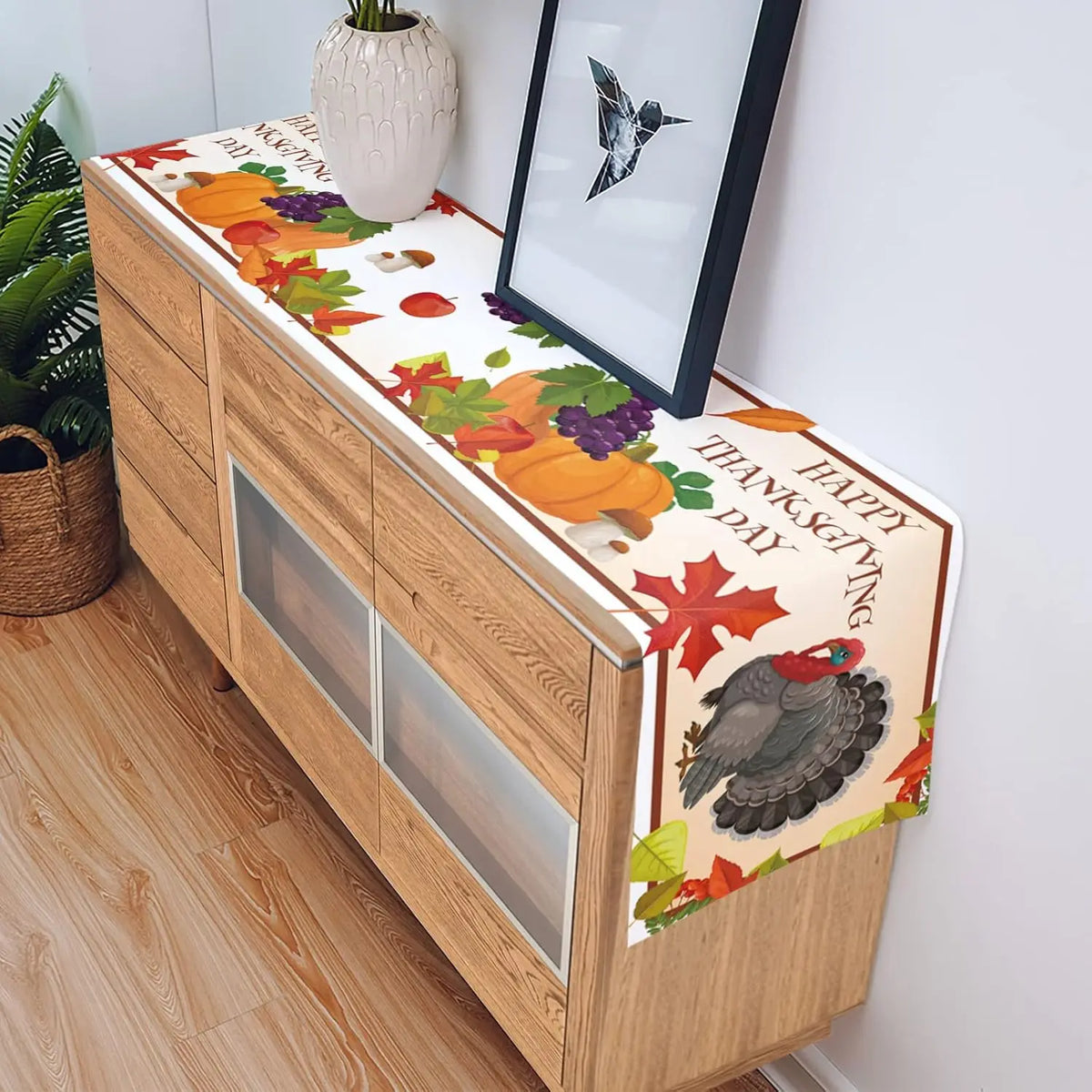 Table de service en bois décorée d'illustrations de fruits d'automne, de feuilles colorées et d'un dindon stylisé, avec un panneau "Happy Thanksgiving" sur le devant.