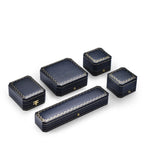 Boîte à bijoux octogonale vintage en cuir PU bleu royal fermée sur une table de nuit élégante