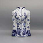 Ce vase décoratif en porcelaine blanche présente un motif floral bleu foncé magnifique, avec des fleurs et des motifs ornementaux élégants répartis sur toute la surface.