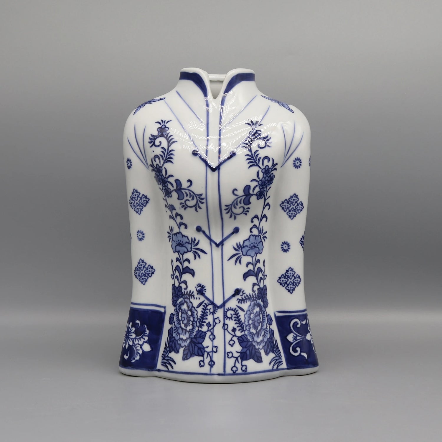 Ce vase décoratif en porcelaine blanche présente un motif floral bleu foncé magnifique, avec des fleurs et des motifs ornementaux élégants répartis sur toute la surface.