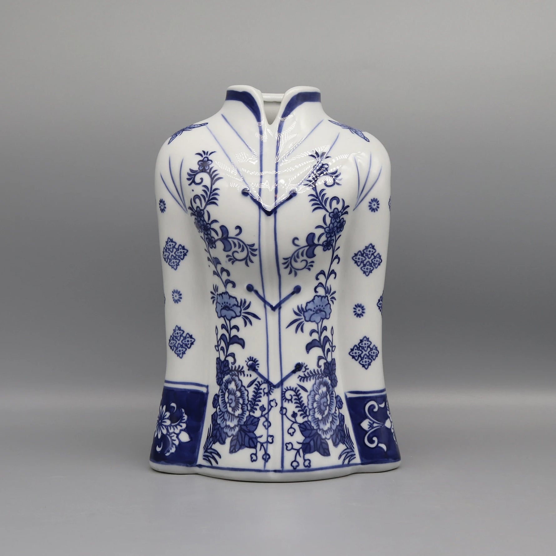 Ce vase décoratif en porcelaine blanche présente un motif floral bleu foncé magnifique, avec des fleurs et des motifs ornementaux élégants répartis sur toute la surface.