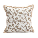 Coussin décoratif beige avec un motif floral brun élégant.