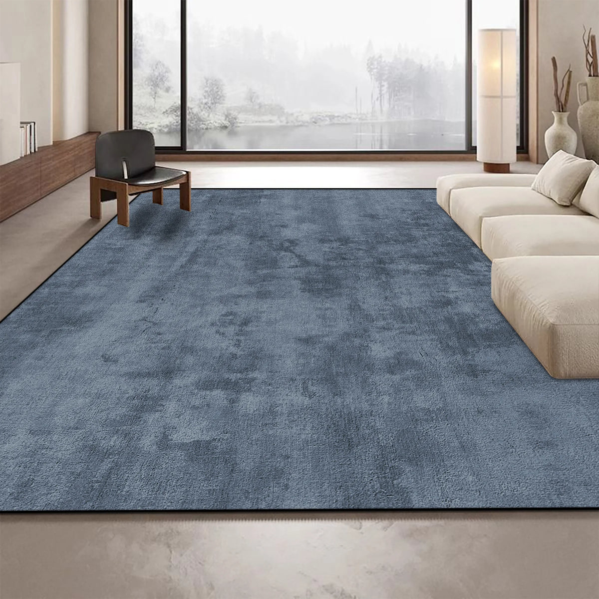 Tapis gris foncé élégant dans un intérieur moderne avec de grandes fenêtres offrant une vue sur un paysage extérieur.