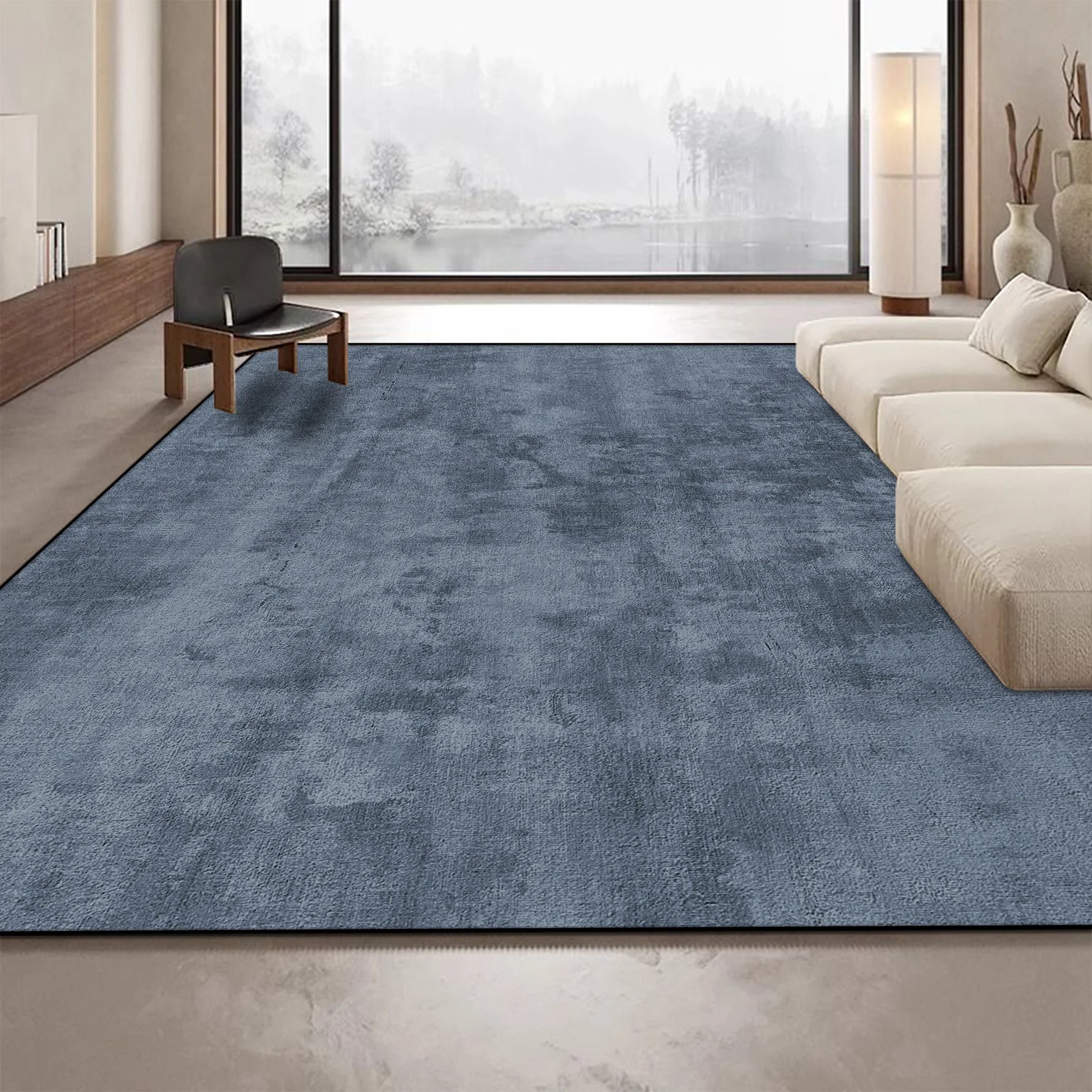 Tapis gris foncé élégant dans un intérieur moderne avec de grandes fenêtres offrant une vue sur un paysage extérieur.