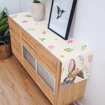 Le meuble de rangement en bois clair est décoré d'un magnifique motif floral et d'un adorable lapin, créant une atmosphère chaleureuse et printanière dans la pièce.