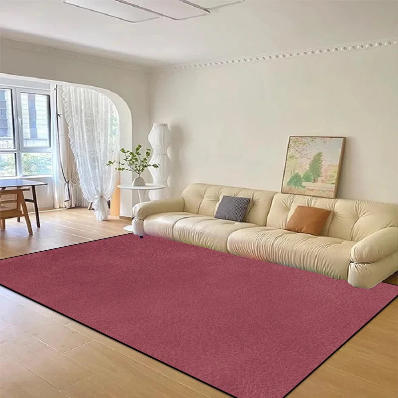 Un salon confortable et lumineux avec un grand canapé crème et un tapis rouge vif au sol.