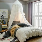 Chambre d'enfant élégante et chaleureuse avec un lit douillet, un ciel de lit blanc gracieux et des accents dorés, entourée de jouets et de décoration murale amusante.