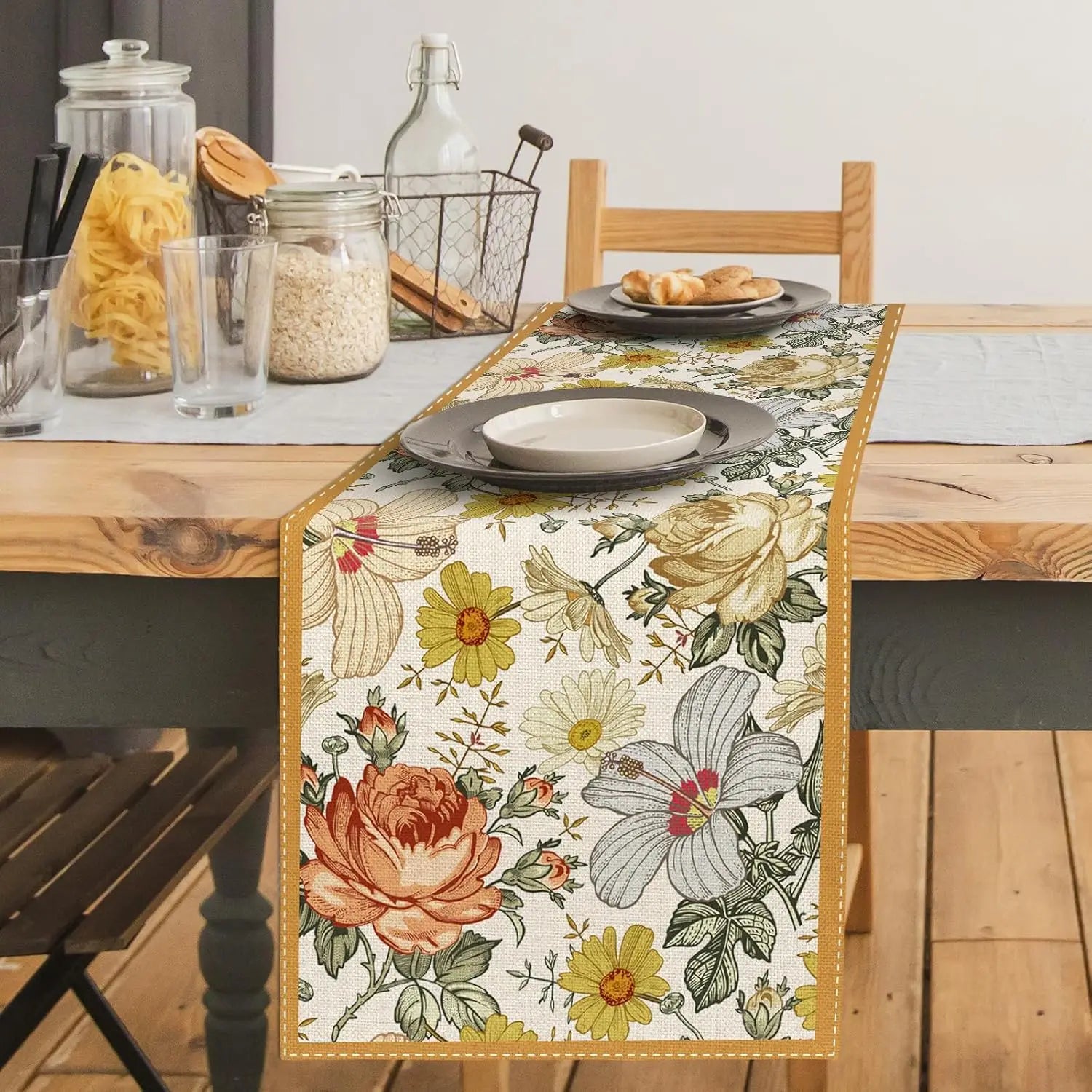 Un chemin de table vintage orné de motifs floraux colorés crée une ambiance chaleureuse et accueillante sur cette table de cuisine rustique.