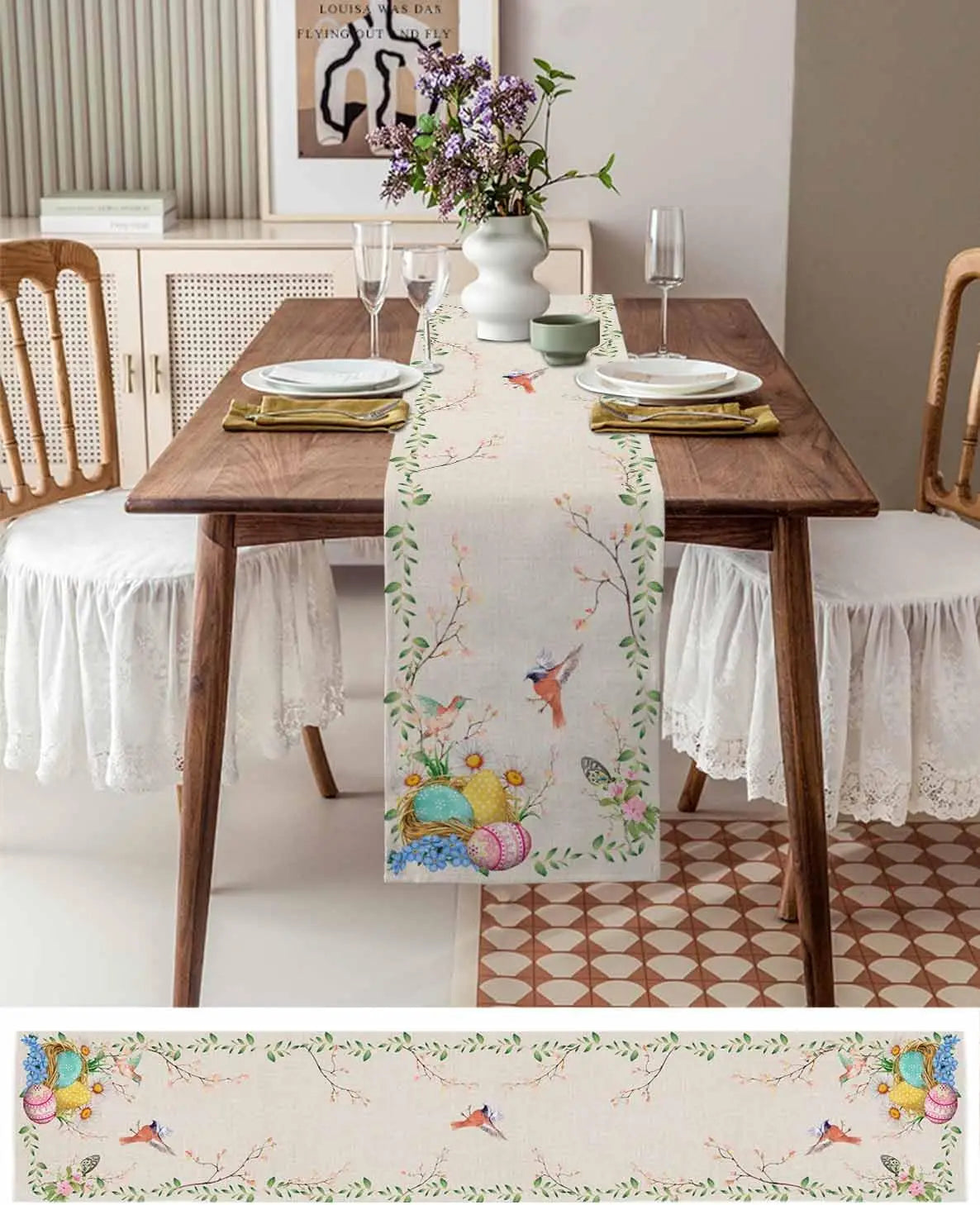 Cette image d'une table de salle à manger décorée montre une nappe aux motifs colorés avec des fleurs, des oiseaux et des œufs de Pâques, créant une atmosphère printanière et chaleureuse.