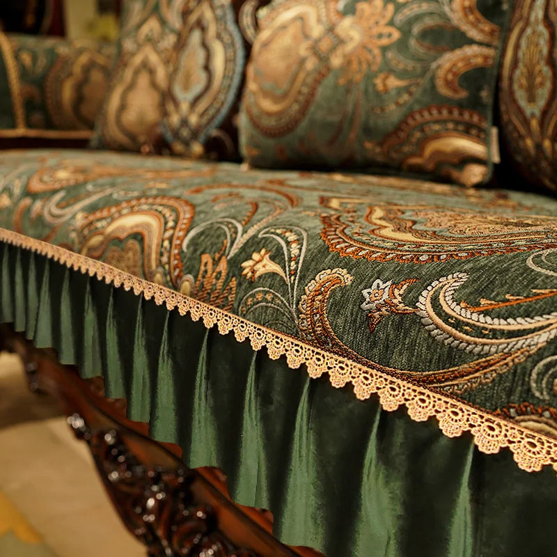 Chaise ou canapé en tissu vert orné de motifs floraux et de dentelle dorée, créant une atmosphère chaleureuse et élégante.