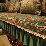 Chaise ou canapé en tissu vert orné de motifs floraux et de dentelle dorée, créant une atmosphère chaleureuse et élégante.